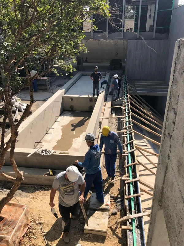 Equipe executando instalação hidráulica de piscina